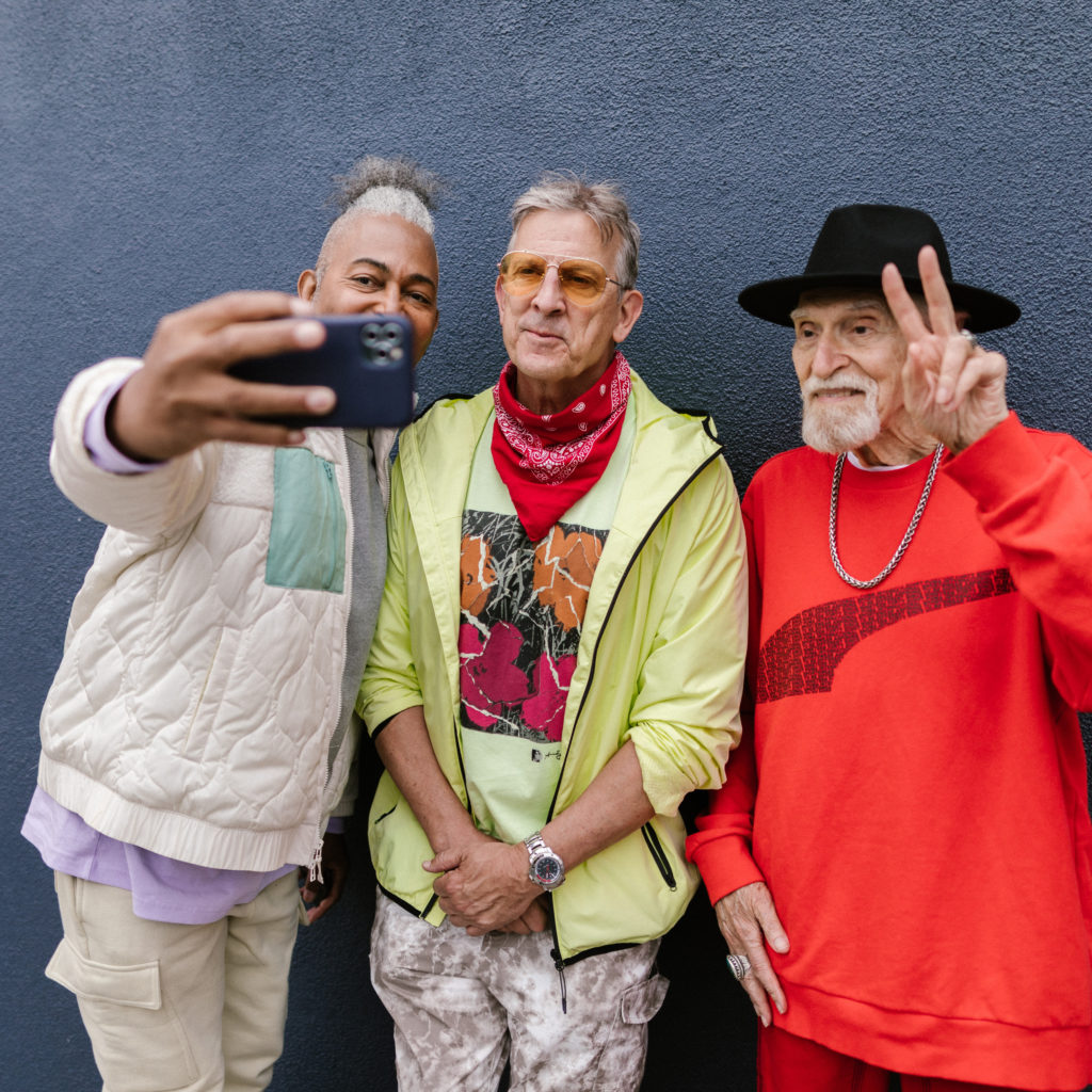 Three older men smiling for a selfie