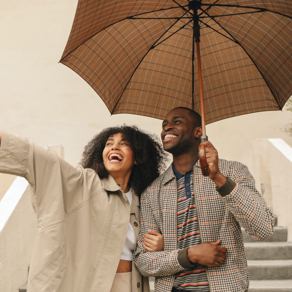 Man and woman under umbrella smiling