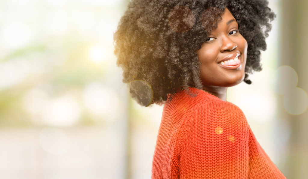 African American woman smiling while looking over her shoulder